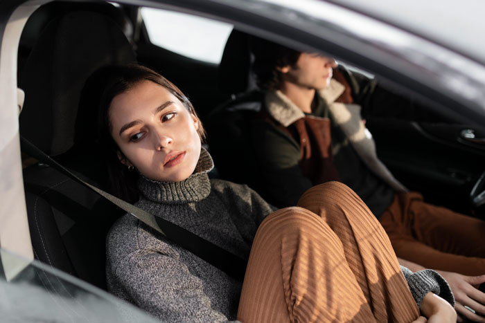 Woman in car looking thoughtful, planning a surprise house prank for her fiancé.