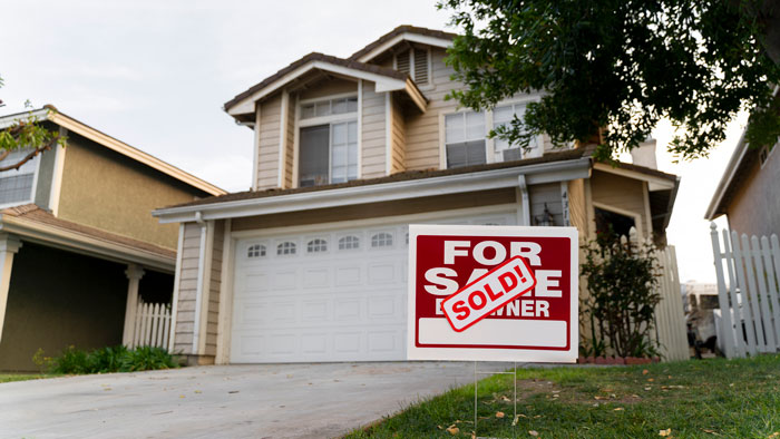 House with a \"Sold\" sign in the yard, part of a fiance surprise house prank.