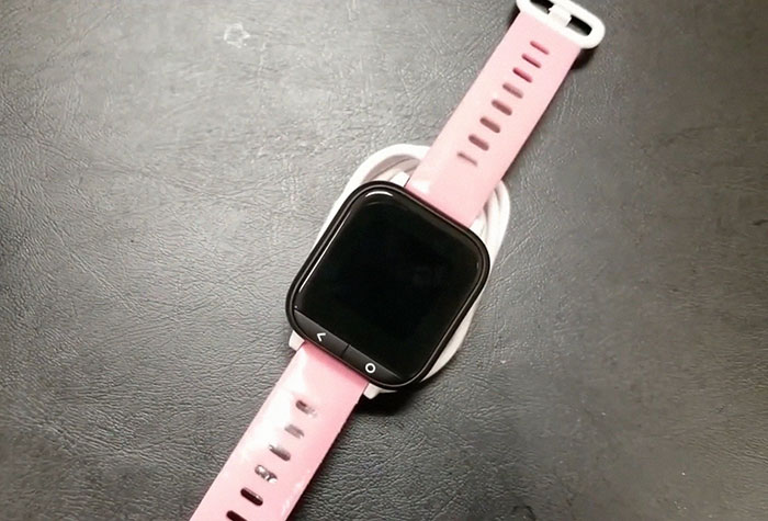 Pink Gizmo Watch on black surface, related to spying incident with woman and ex-husband.