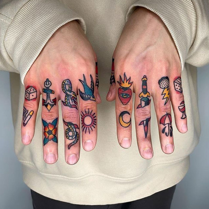 Finger tattoos featuring vibrant symbols and designs on both hands.