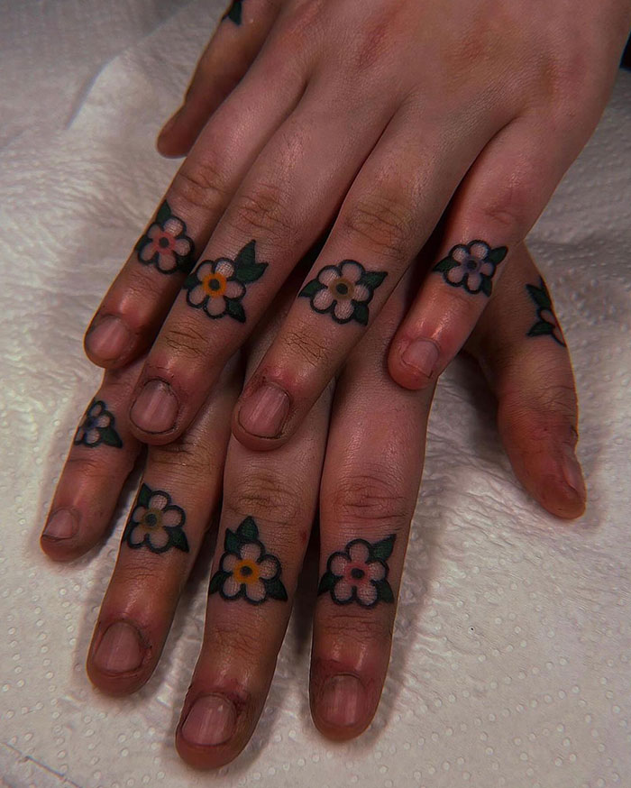 Floral finger tattoos design with colorful flowers on each finger.