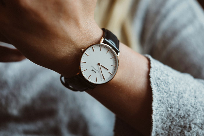 Woman checking her watch while waiting for a late friend at lunch.