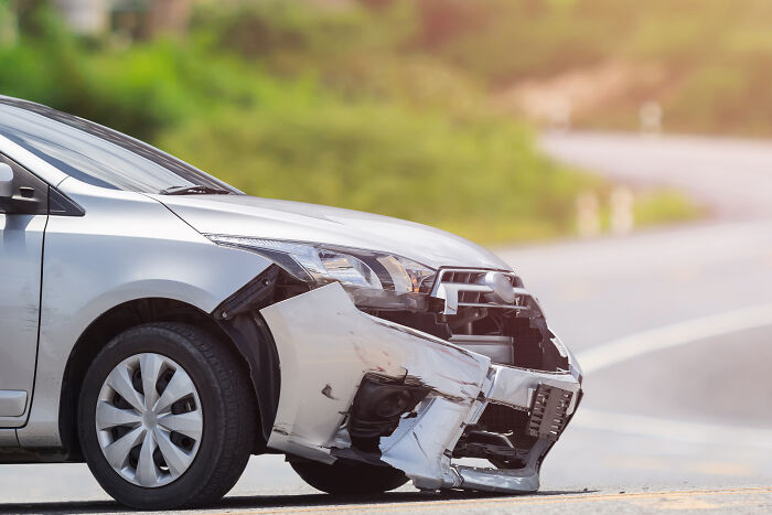 Damaged luxury car with a crumpled front bumper, highlighting rich kids’ disconnect from real-world consequences.