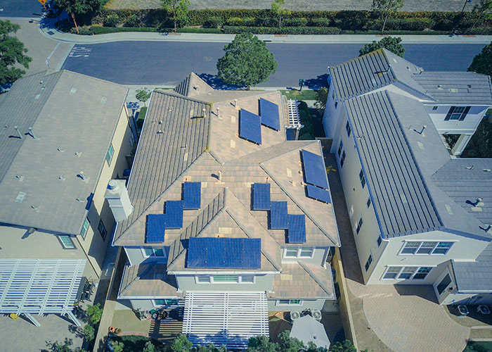 Aerial view of a house with solar panels on the roof, showcasing a creative frugal hack for saving money on energy bills.