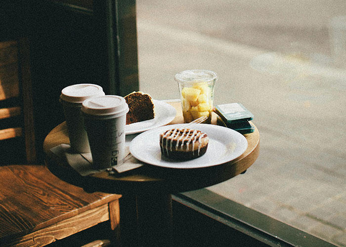 Coffee and pastries on a small table, illustrating creative frugal hacks for affordable breakfast ideas.