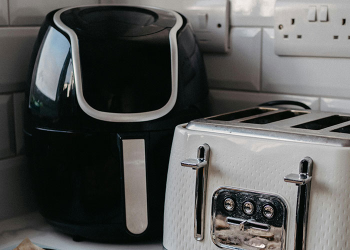 Air fryer and toaster on a kitchen counter, showcasing creative frugal hacks to save cash.