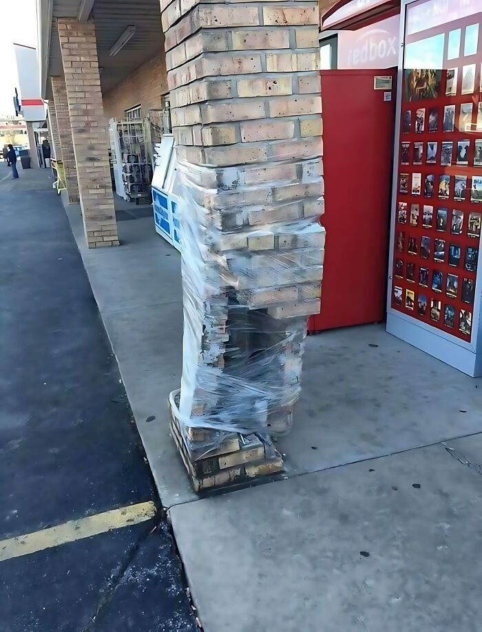 Damaged brick column poorly wrapped in plastic, illustrating a construction fail at a store entrance.