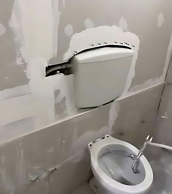 Toilet installed incorrectly with a mismatched flush tank, illustrating a construction fail.