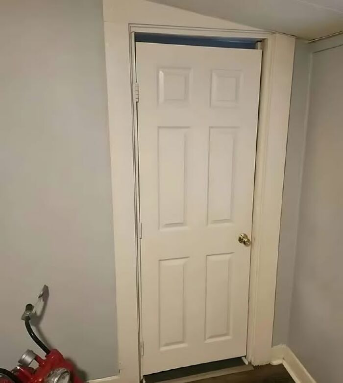 A poorly installed door with a misaligned frame showcases a construction fail indoors.