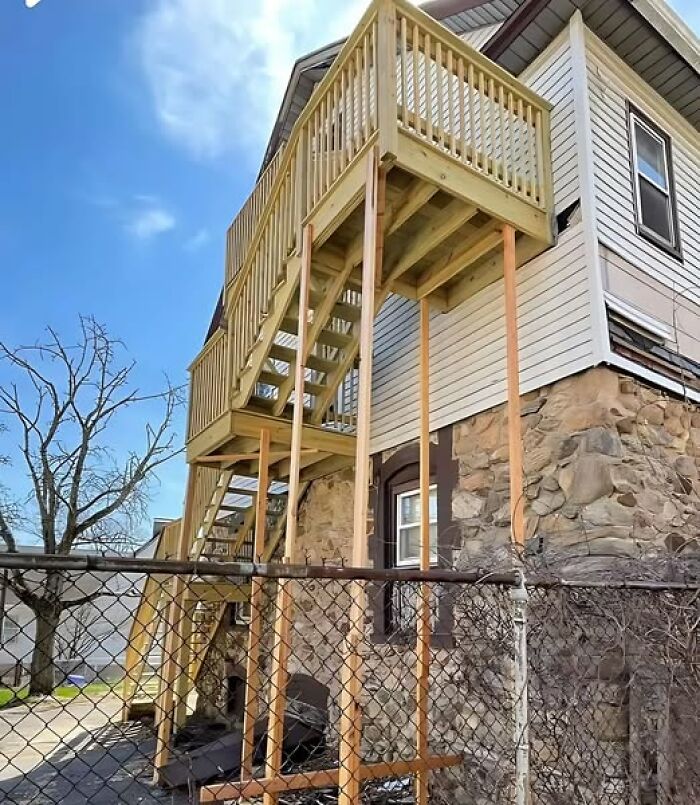 Badly constructed outdoor staircase with flimsy wood supports, highlighting construction fails.