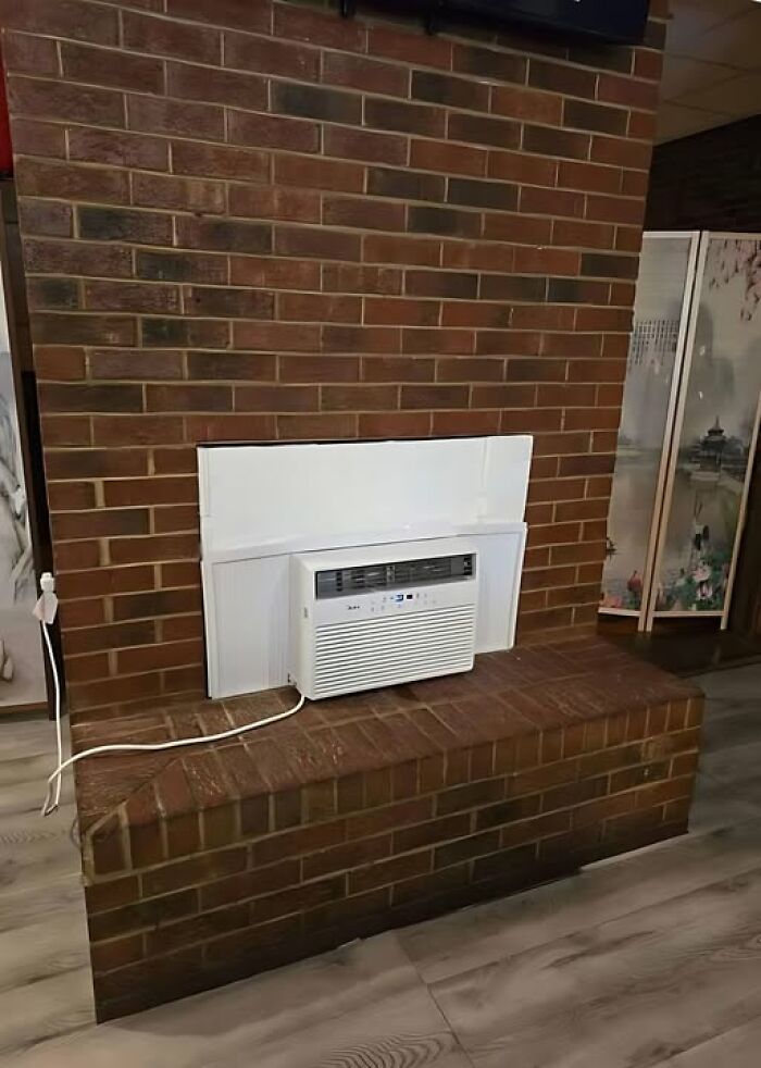 Air conditioner installed into a brick wall in a humorous construction fail.