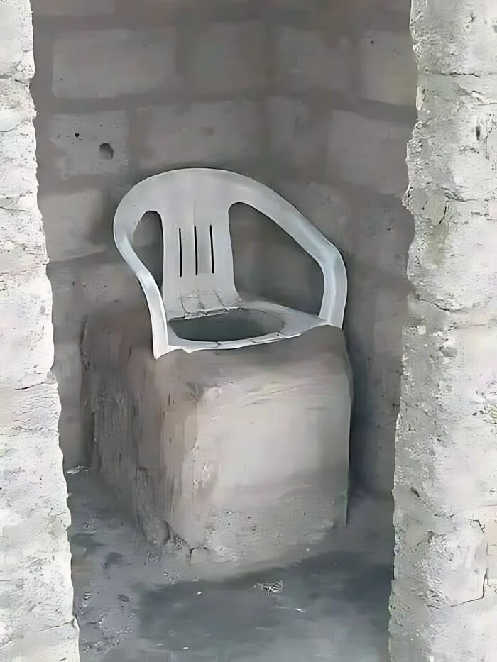 Plastic chair awkwardly installed on concrete block, highlighting a hilarious construction fail.