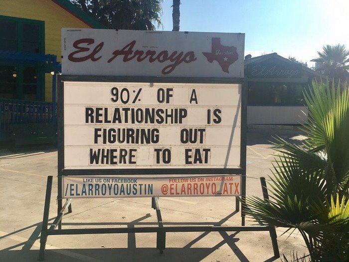 El Arroyo sign reads "90% of a relationship is figuring out where to eat" in sunny outdoor setting.