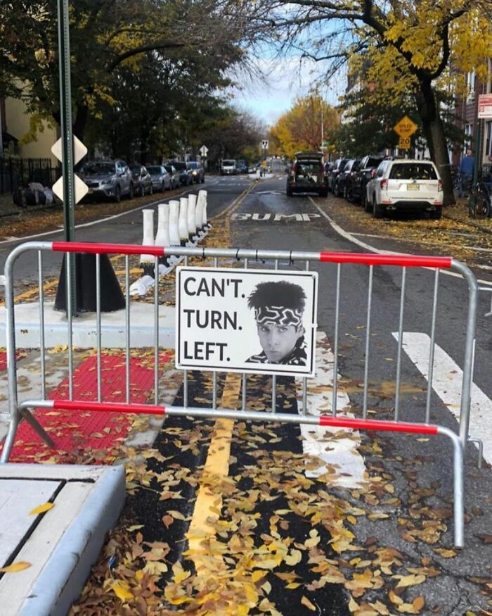 New York street with a funny sign reading "Can't Turn Left," displaying a person's face.