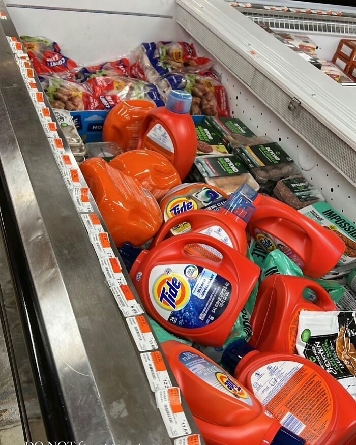 Detergent bottles placed in a grocery freezer section alongside frozen foods, illustrating funny New York moments.