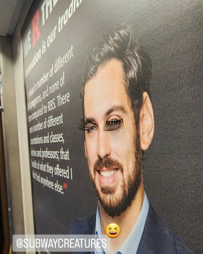 Funny pic in New York subway with fake eyelashes on a poster man, creating a humorous effect.