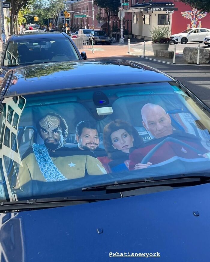 Car windshield sunshade featuring Star Trek characters, creating a humorous scene.