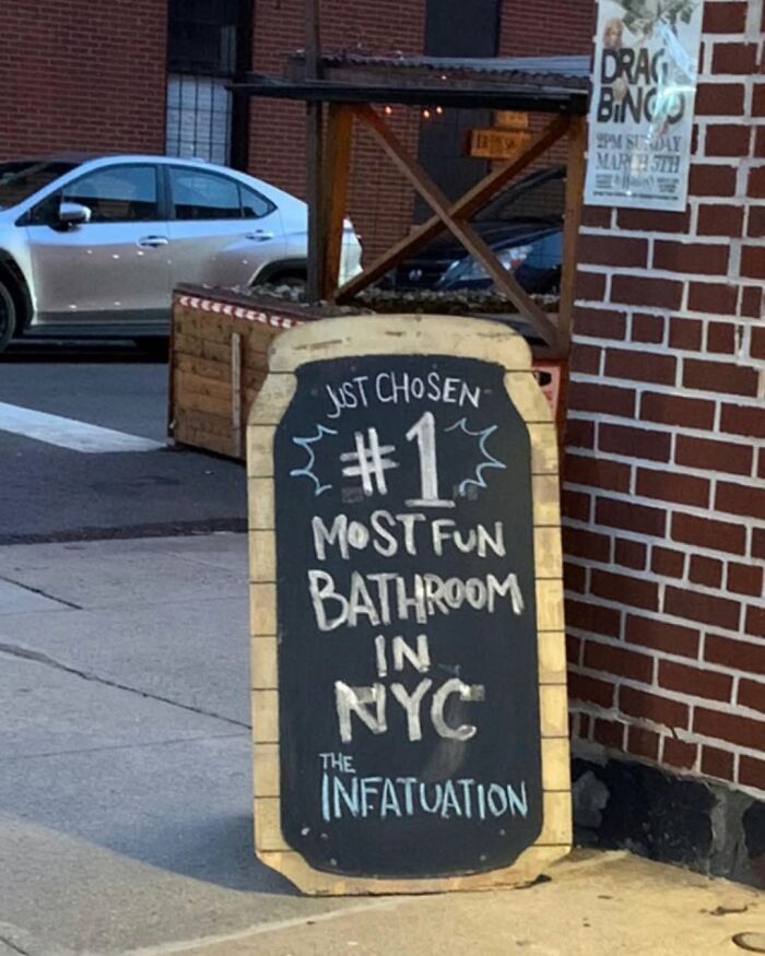 A chalkboard sign in New York claiming to have the most fun bathroom in NYC.