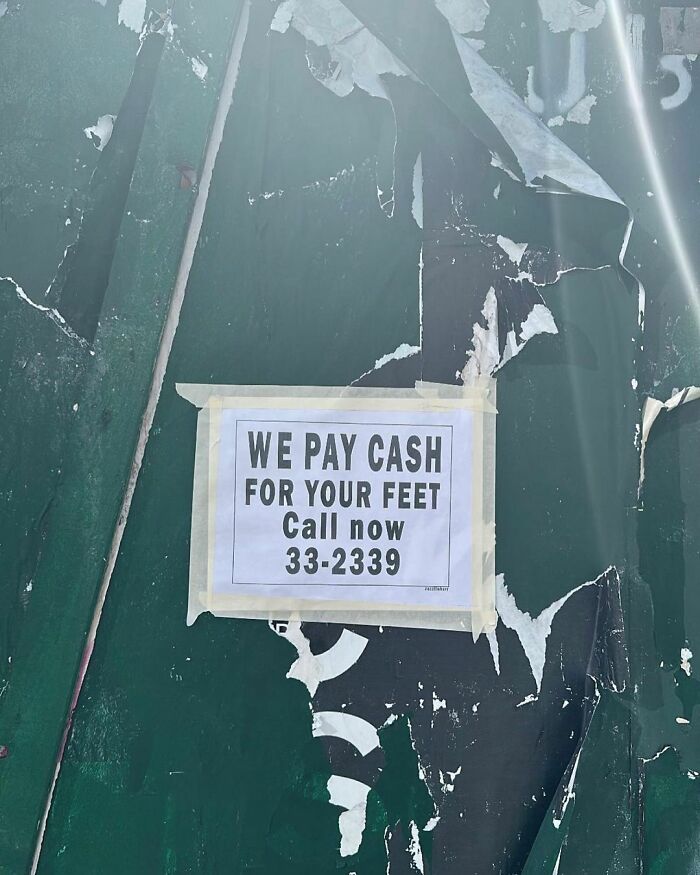 Sign on a wall in New York offering cash for feet, displaying unusual humor.