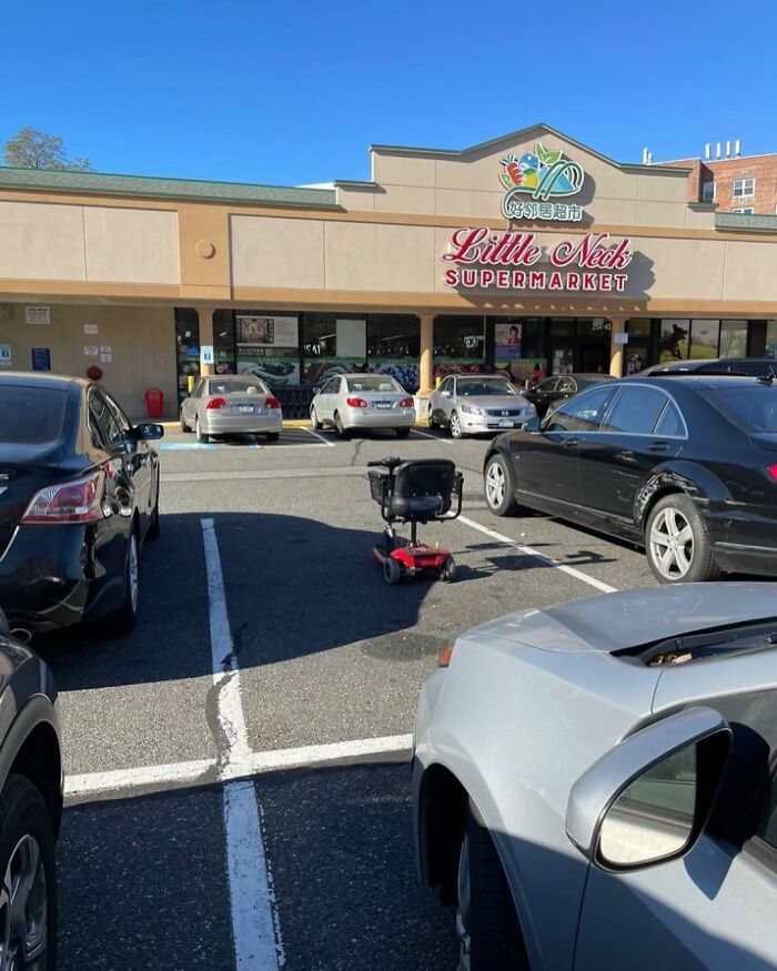 Mobility scooter in a parking spot at Little Neck Supermarket, New York.