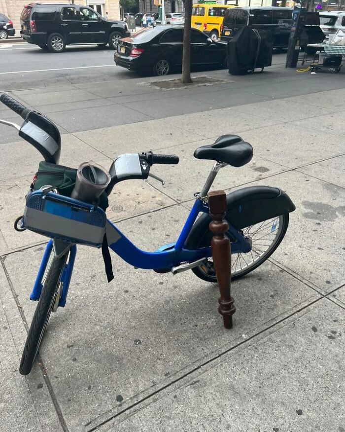 Bike with makeshift wooden leg parked on a New York street.