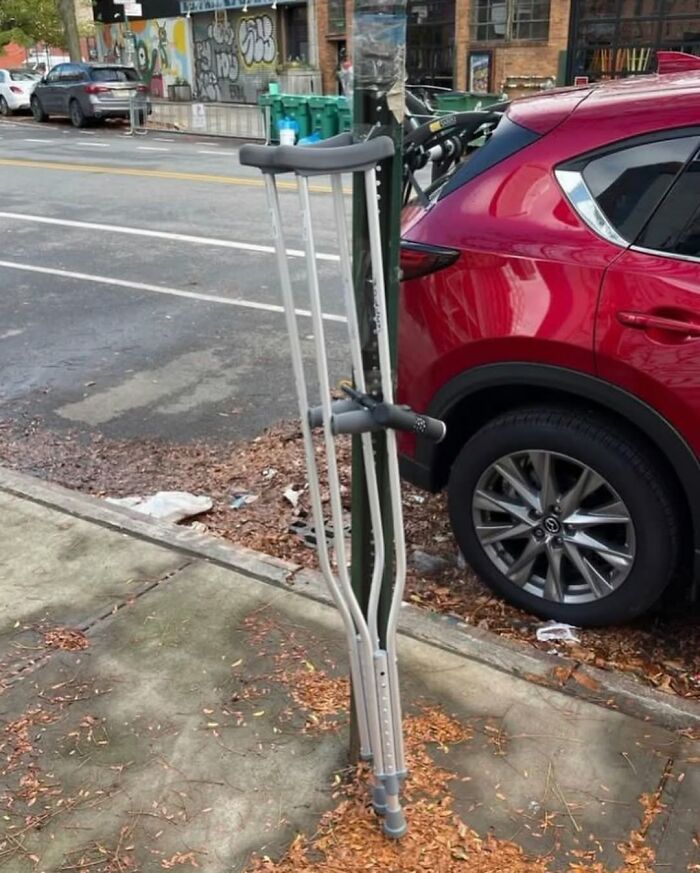 Crutch humorously locked to a pole in New York street scene.