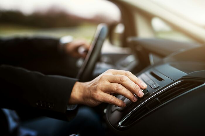 Driver adjusting car radio, illustrating insane coincidences and surprises.