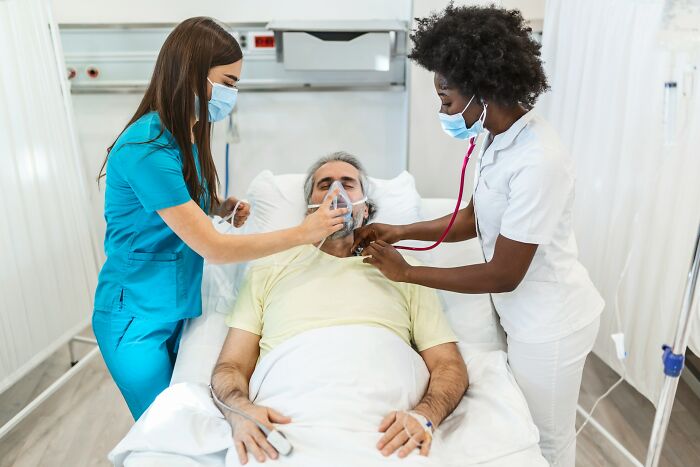 Doctors tending to a patient in a hospital bed, highlighting the importance of exercise in healthcare advice.