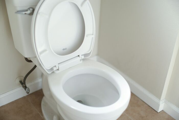 A clean white toilet in a bathroom, highlighting hygiene habits.