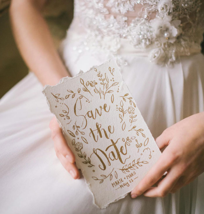 "Close-up of a bride holding a 'Save the Date' card in her hands, related to destination wedding struggles.