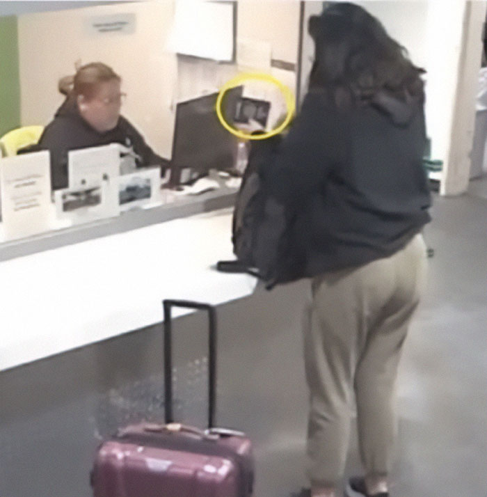 Person with luggage at reception desk, linked to green card marriage scam investigation.