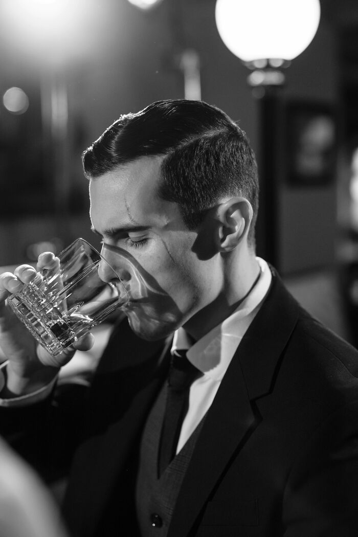 Man in suit drinking whiskey; a relationship red flag profession depicted.