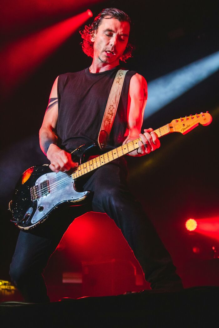 Musician passionately playing electric guitar on stage, symbolizing a relationship red flag profession.