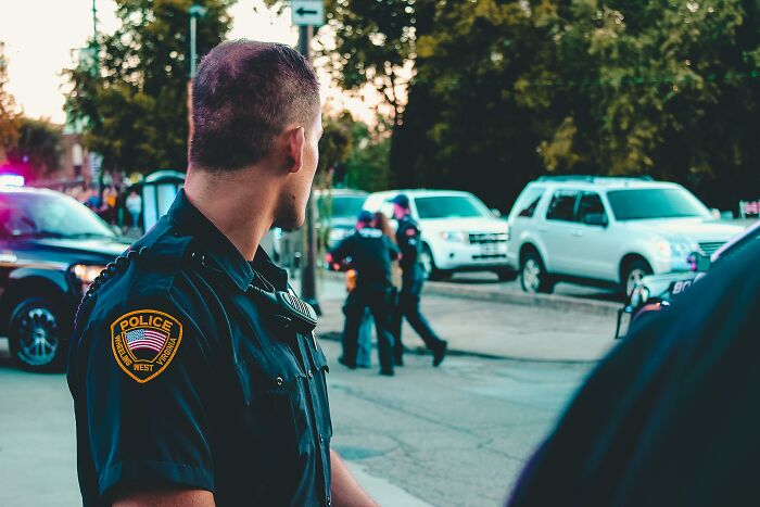 Police officer monitoring a street scene, suggesting relationship red flags tied to certain professions.