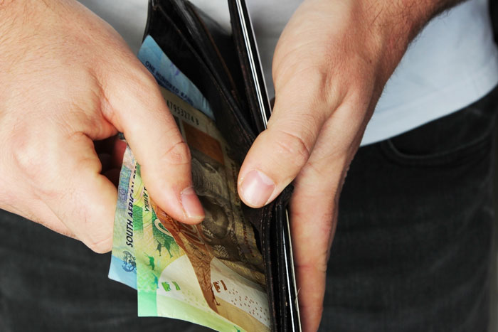 A person holding a wallet with cash, representing help with finances and debt.