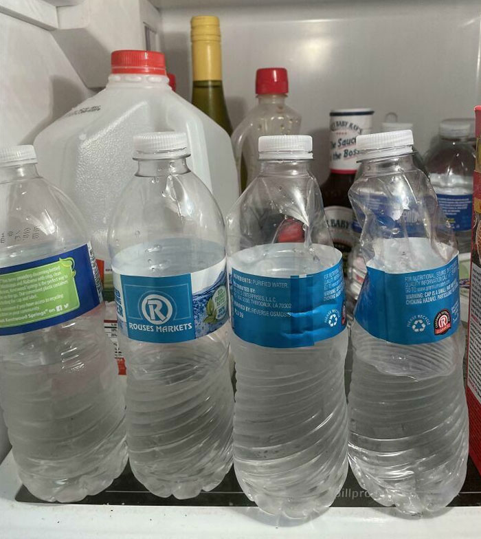 Partially consumed water bottles in a messy refrigerator, showcasing horrible roommates' habits.