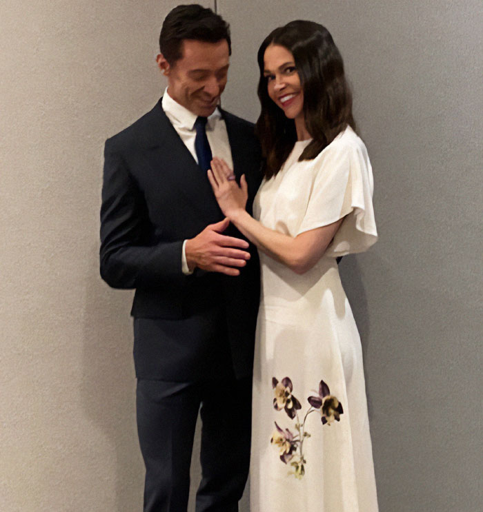 Hugh Jackman with a woman in a white dress, sparking rumors.