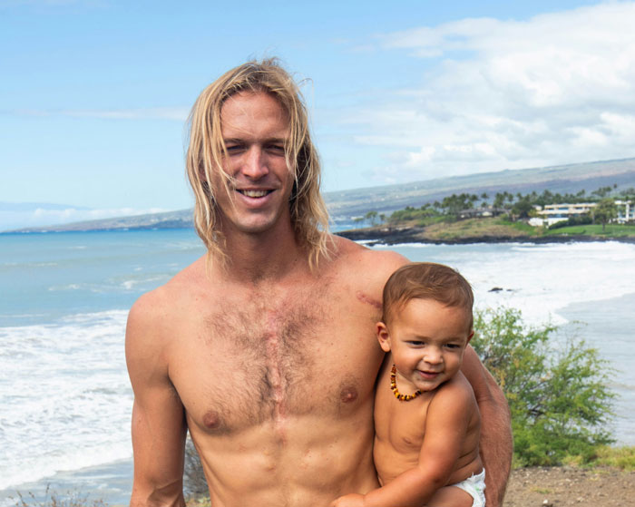 Man holding a toddler on a beach with waves in the background, highlighting family connection issues over features.