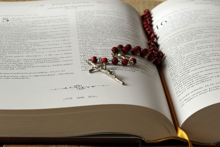 Open book with red rosary, symbolizing industries built on fooling people.