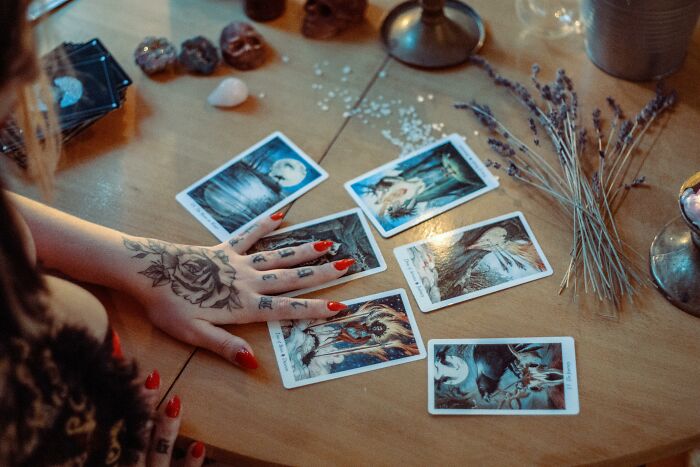 Tarot reading session with cards on a wooden table, highlighting industries based on deception.