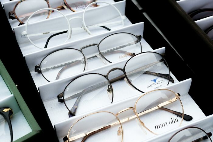 A selection of eyeglasses displayed in a case, showcasing various styles and brands.