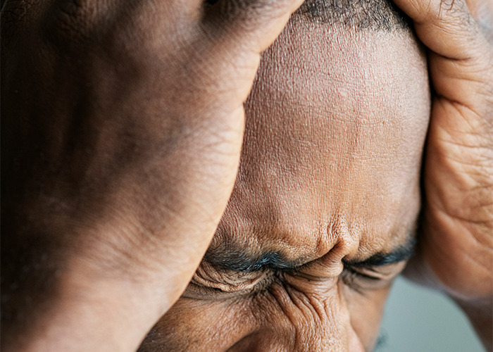 Close-up of a man holding his head in frustration, representing real-life insurance horror stories.