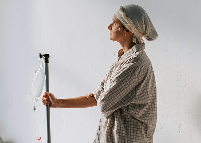 A person in a hospital gown with an IV, illustrating a real-life insurance story.