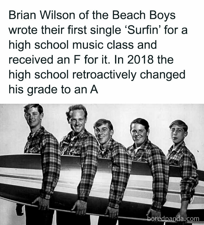 Beach Boys with surfboard, highlighting interesting fact about Brian Wilson's retroactive grade change for 'Surfin'.