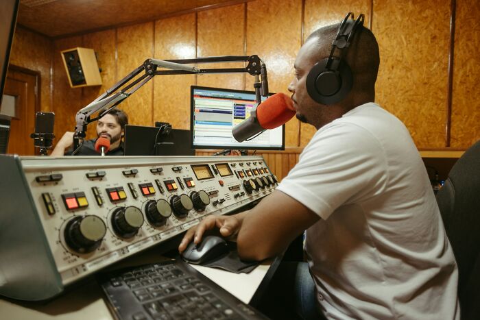 Radio hosts at work, highlighting the reality of fun jobs in a recording studio setting.