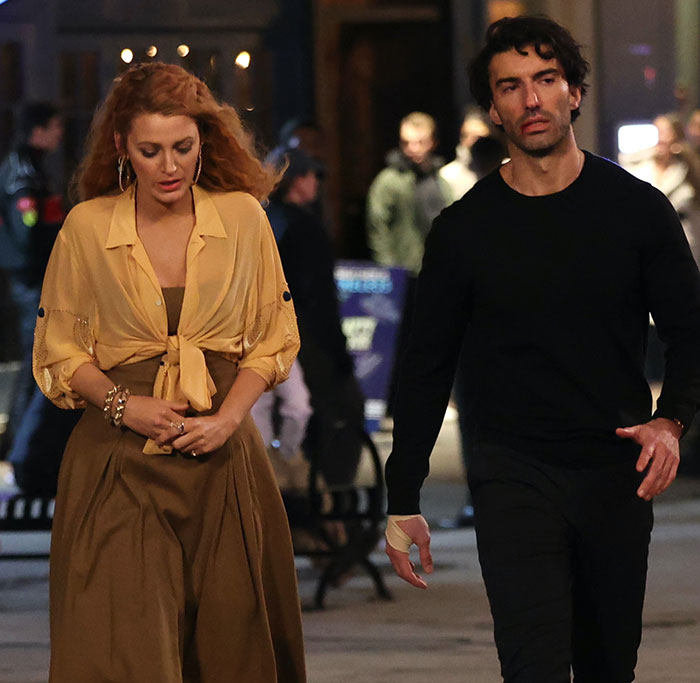 Justin Baldoni and a woman walking on a busy street at night, highlighting lawyer claims about truth exposure.