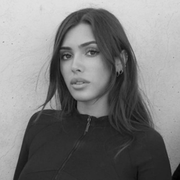 A black-and-white portrait of a woman with long dark hair, wearing a zipped-up top, associated with Kanye West's new wife.