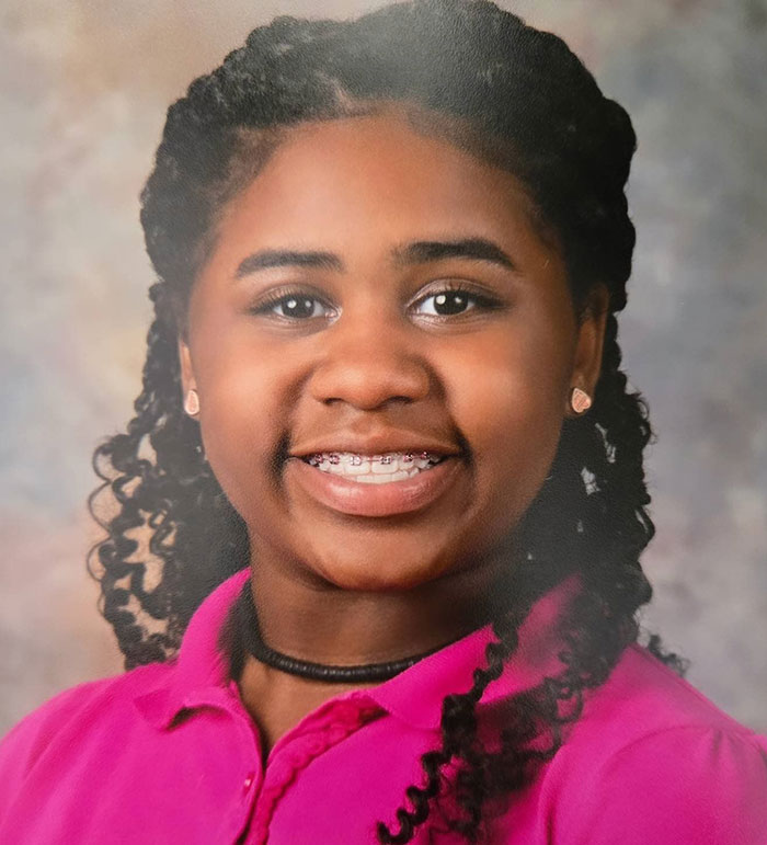 Kelaia Turner smiling with braces and curly hair, wearing a pink shirt, related to bullying and abuse incident.