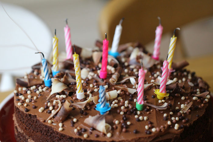 Chocolate cake with colorful birthday candles ready for kids to blow out.