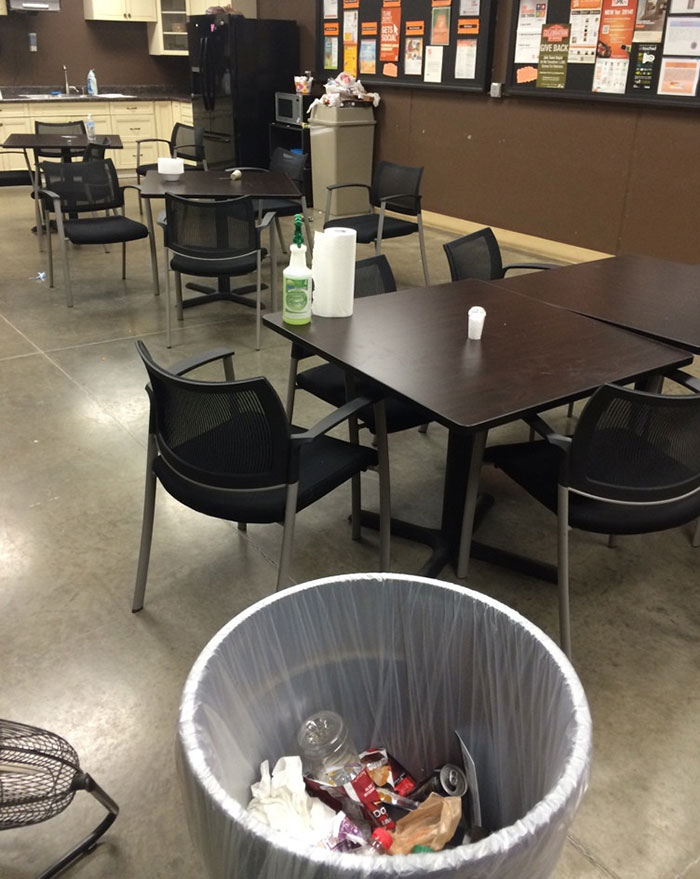 Empty lunchroom with trash bin full; lazy-infuriating-people scenario.